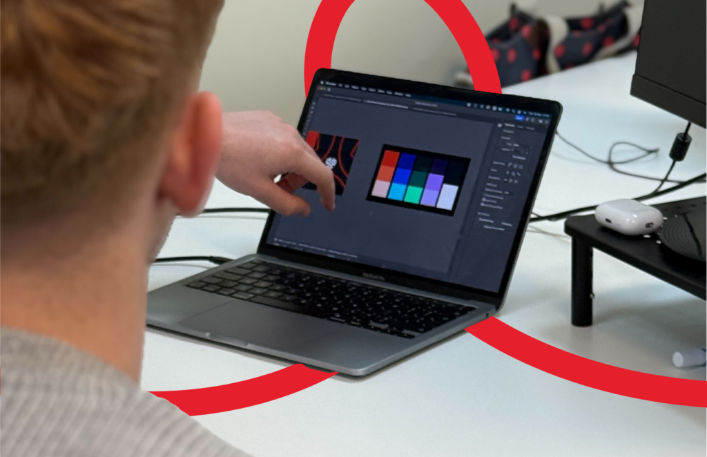 A customer experience designer showing his laptop screen to a colleague.